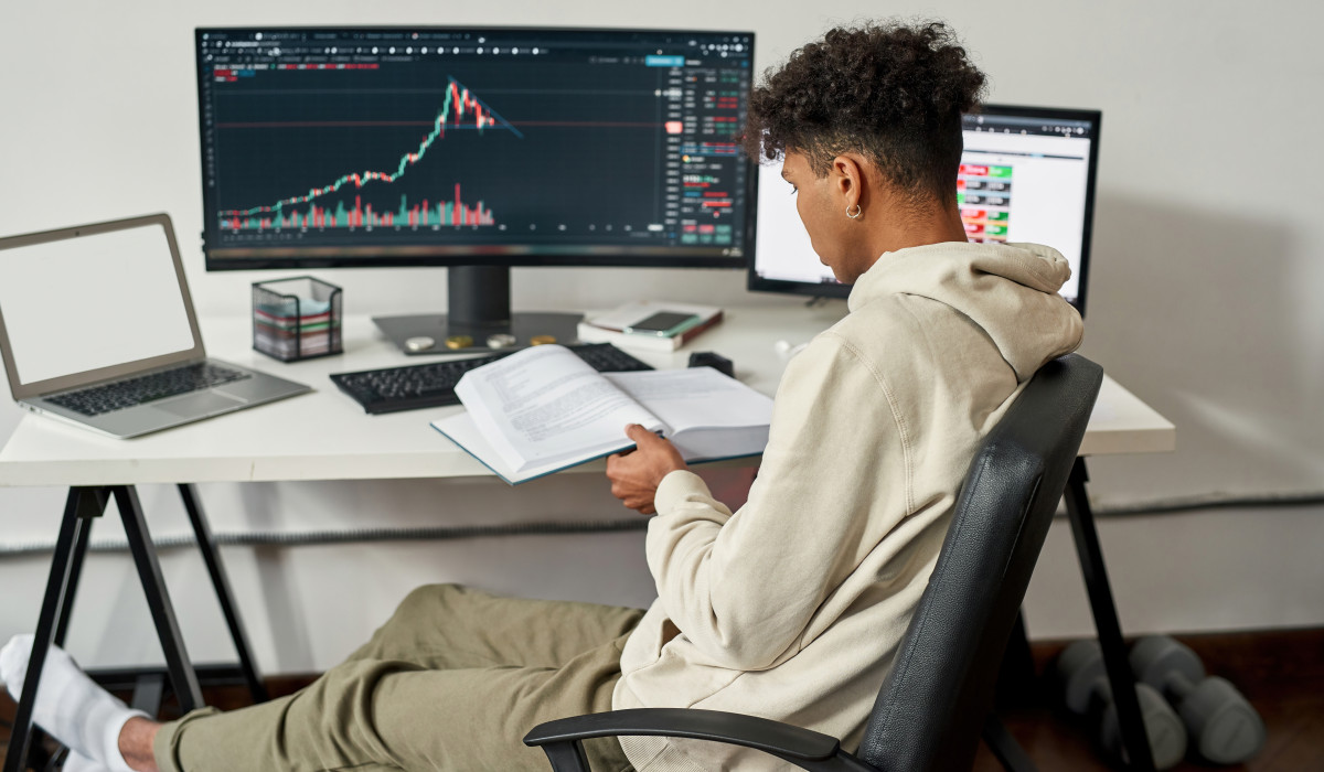 Jugendlicher verfolgt Kryptowährung online am Computer. 